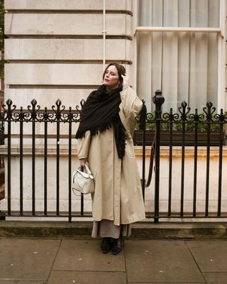 @annacascarina wearing a trench coat and scarf