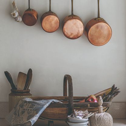A rustic kitchen with hanging copper pots