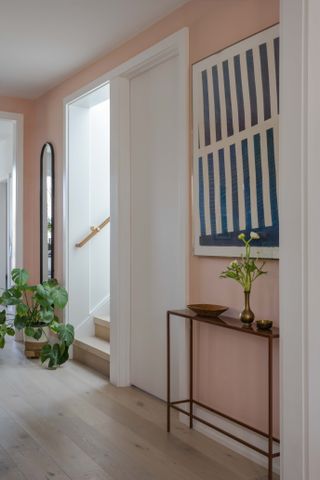 hallway with light pink walls and staircase opening
