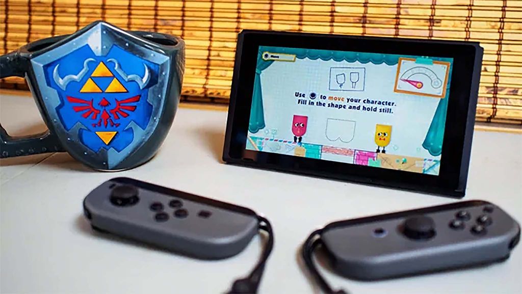 Nintendo Switch with controllers detached and running Snipperclips, a co-op multiplayer game.