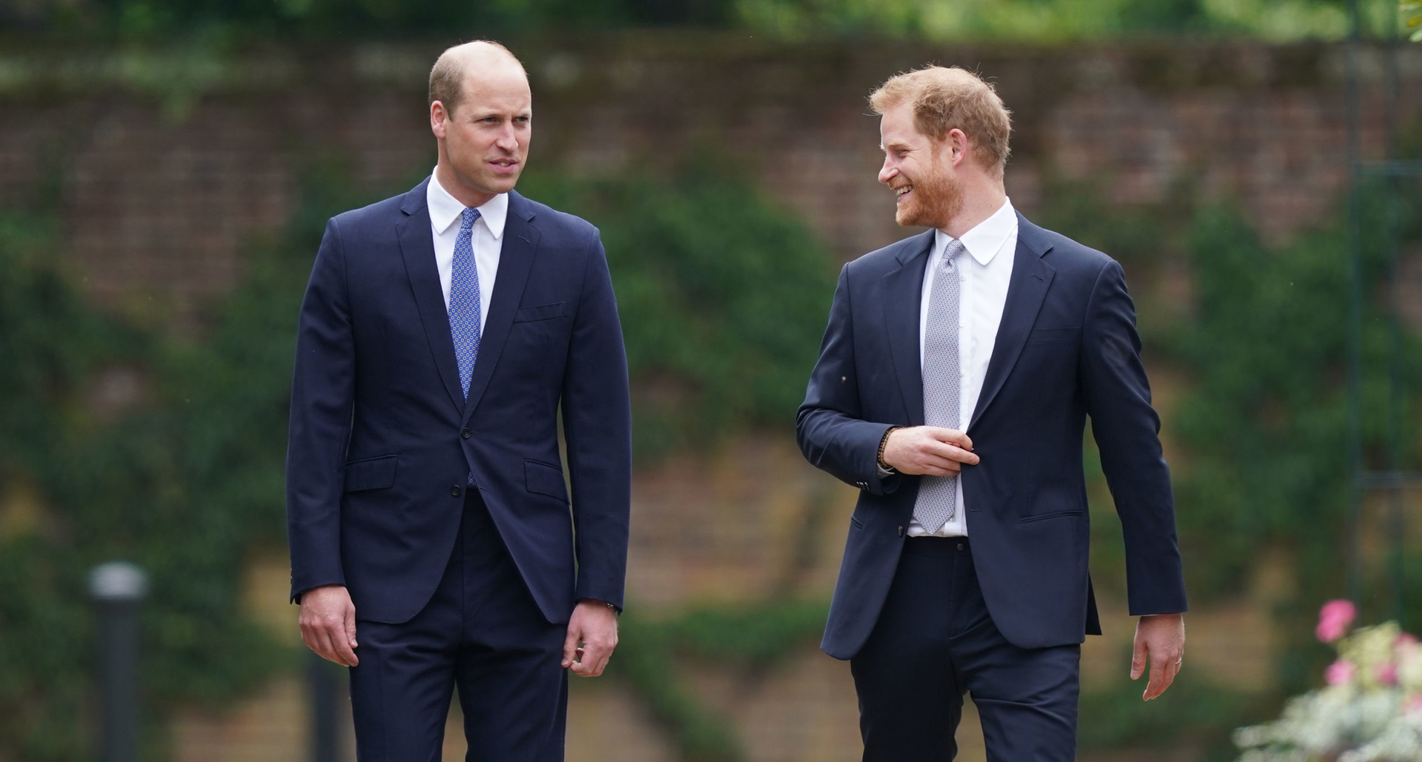Prince William wearing a suit walking with Prince Harry at Kensington Palace