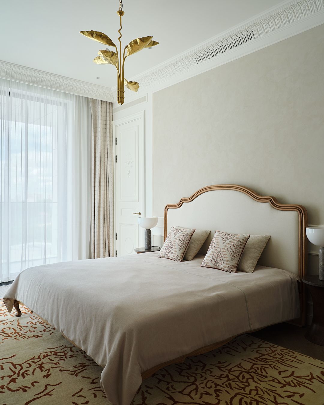 A serene bedroom with a gold accent chandelier