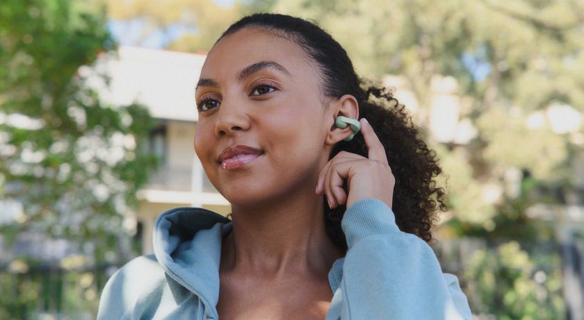 Woman wearing the Sony LinkBuds Clip and touching the left earbud