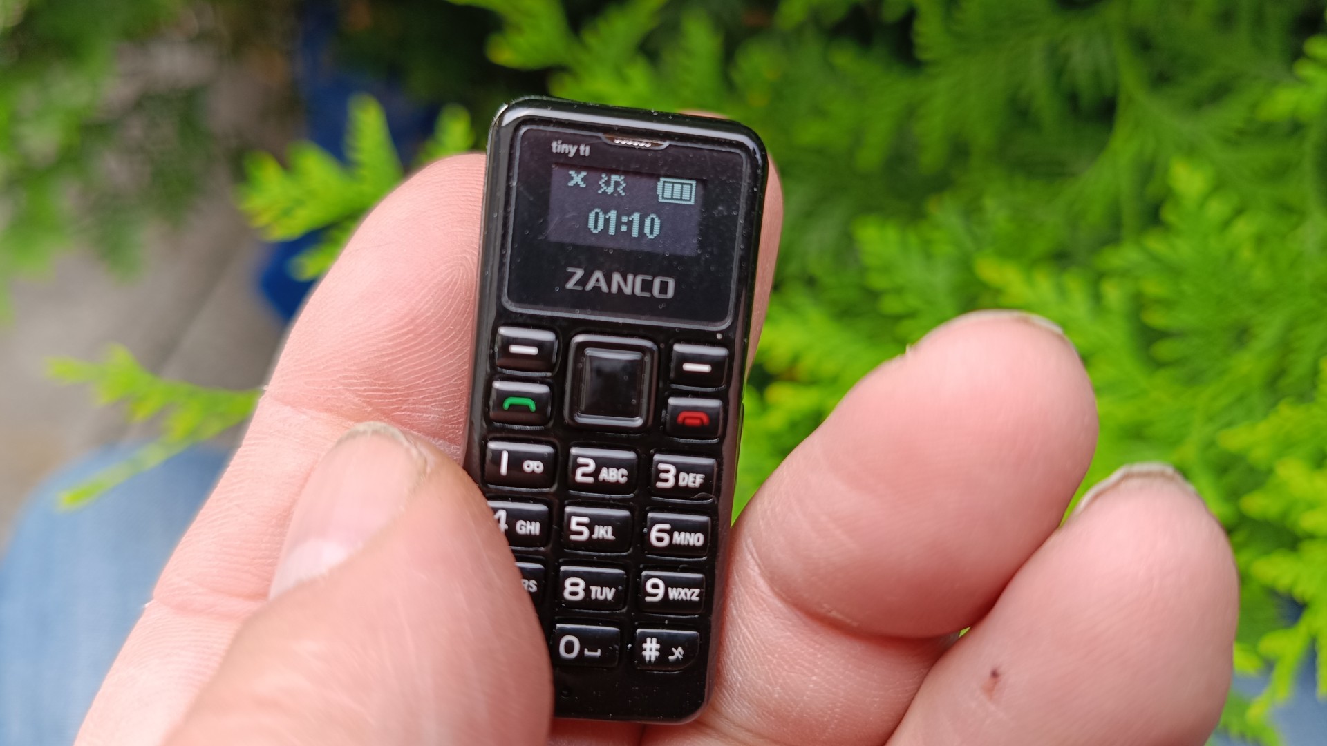 Zanco Tiny T1 phone in hand with display showing the time