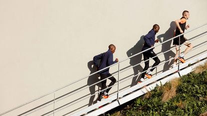 best running tights: Pictured here, three athletes running up some steps, two of them wearing compression tights
