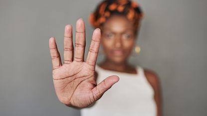 Woman holds up her hand to signal STOP.