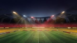 An empty football field lit in the colours of the German flag
