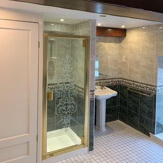 before image of a dated bathroom with gold shower