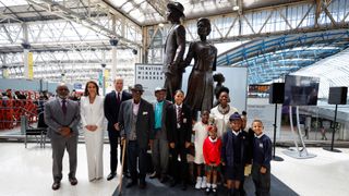 Prince William and Catherine, Duchess of Cambridge accompanied by Baroness Floella Benjamin, Windrush passengers Alford Gardner and John Richards and children pose for a picture next to the National Windrush Monument