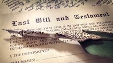 A last will and testament document with a fancy fountain pen sitting on top.