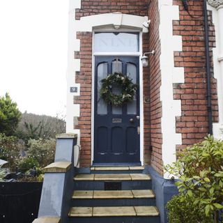 blue front door with Christmas wreath on