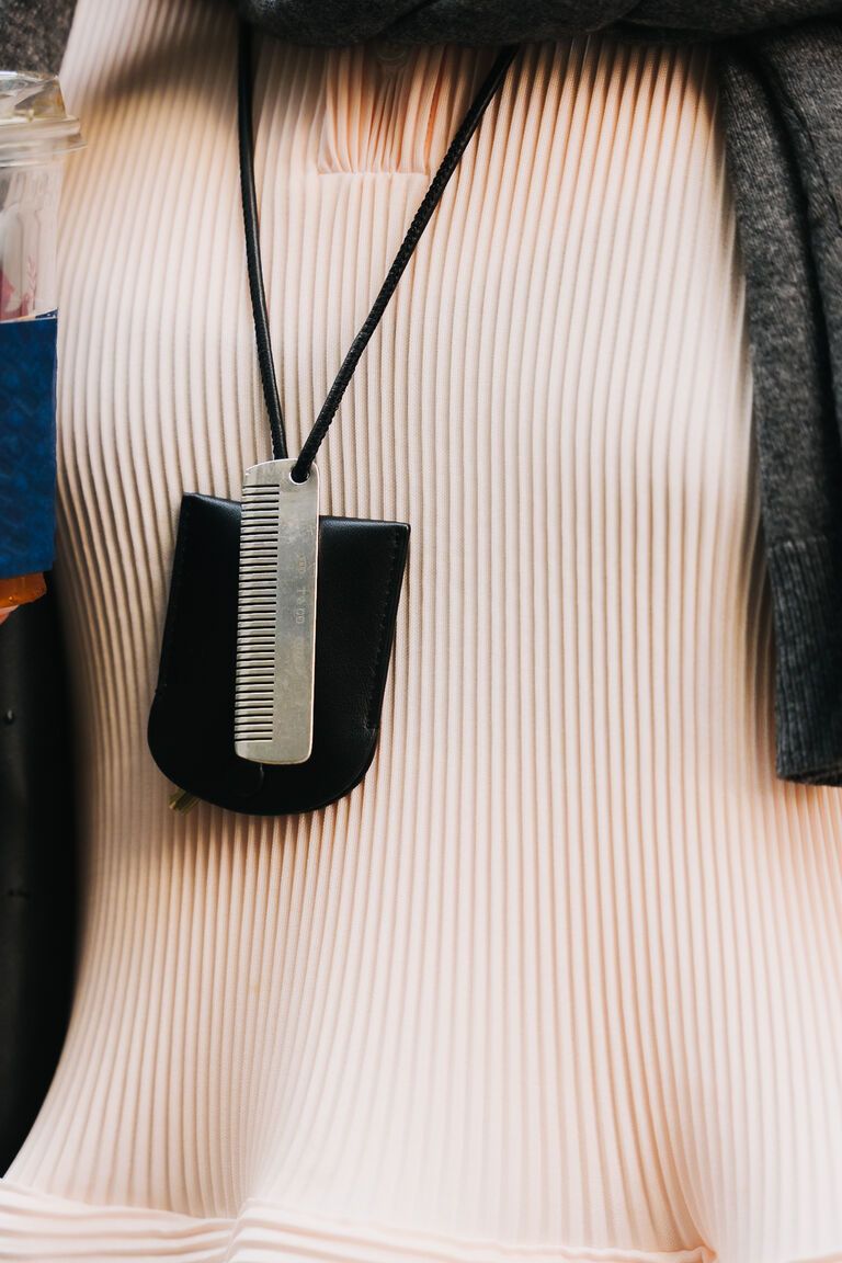 summer 2026 jewelry trends, woman at new york fashion week wearing a black leather case and silver comb pendant necklace