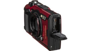 Angled side view of Olympus Tough TG-6 compact camera, showing open USB ports
