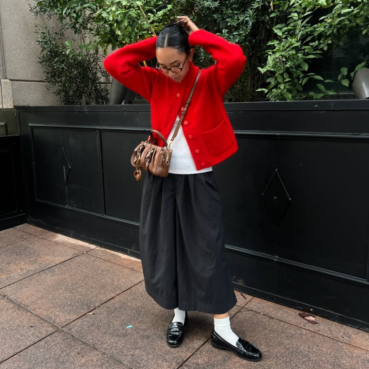 Influencer Stephanie Arant wearing culottes, red cardigan and loafers. 
