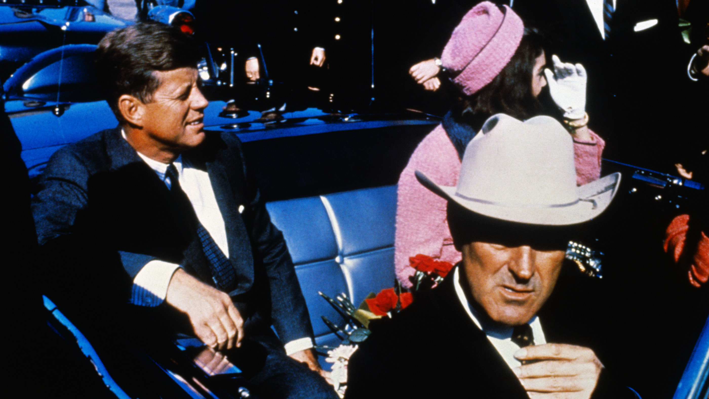 President John Kennedy rides in a motorcade from the Dallas airport into the city with his wife Jacqueline and Texas Governor John Connally.
