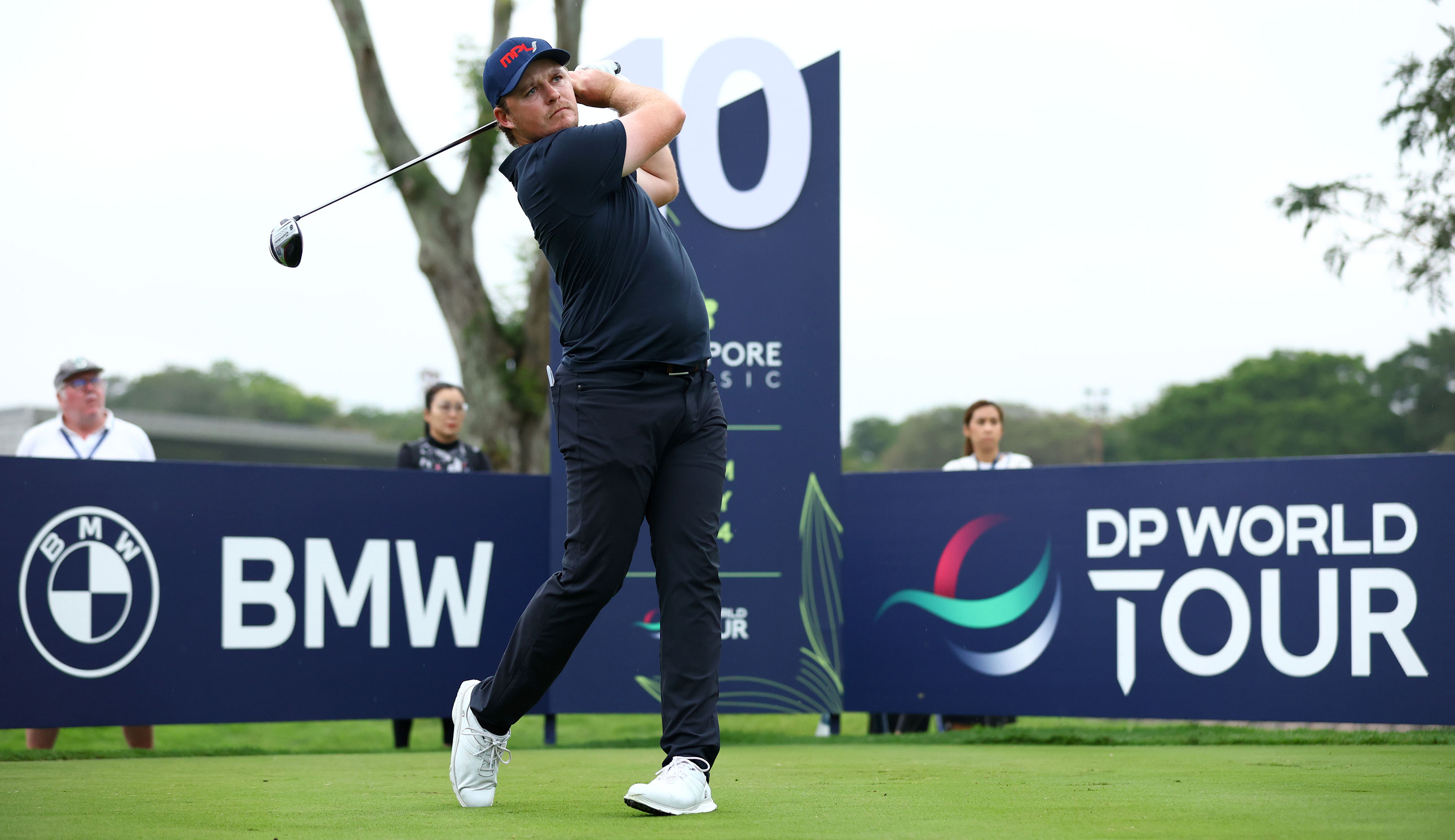 Eddie Pepperell hits a tee shot in front of advertising boards