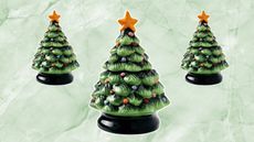 three of the green aldi ceramic christmas tree candles on a green marble background