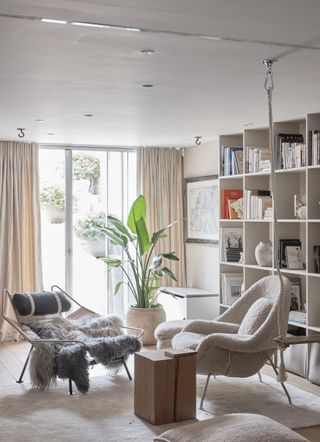 A living room seating area with an indoor swing, garden doors and shelves, and modern furniture.