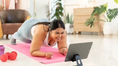 Woman doing a forearm plank on a yoga mat.