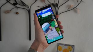 Google Pixel 7 in hand shown playing a game