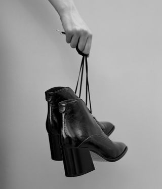 Black leather heeled boots held by the laces