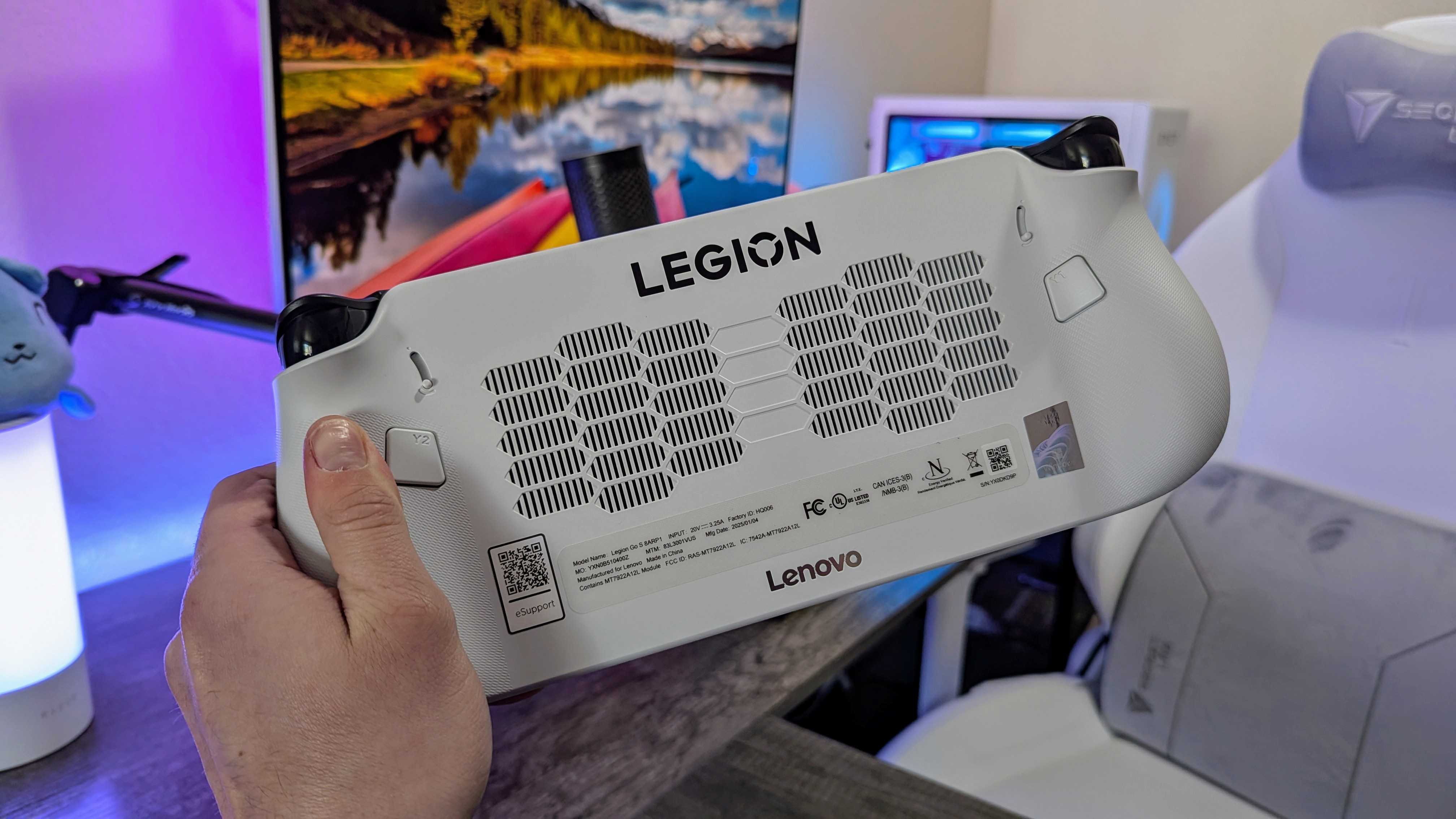 The Lenovo Legion Go S held in a hand, showing the rear vents and buttons.