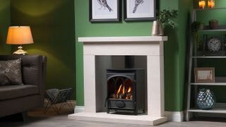 gas stove with white fire surround and green wall
