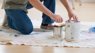 a person opening a tin of paint