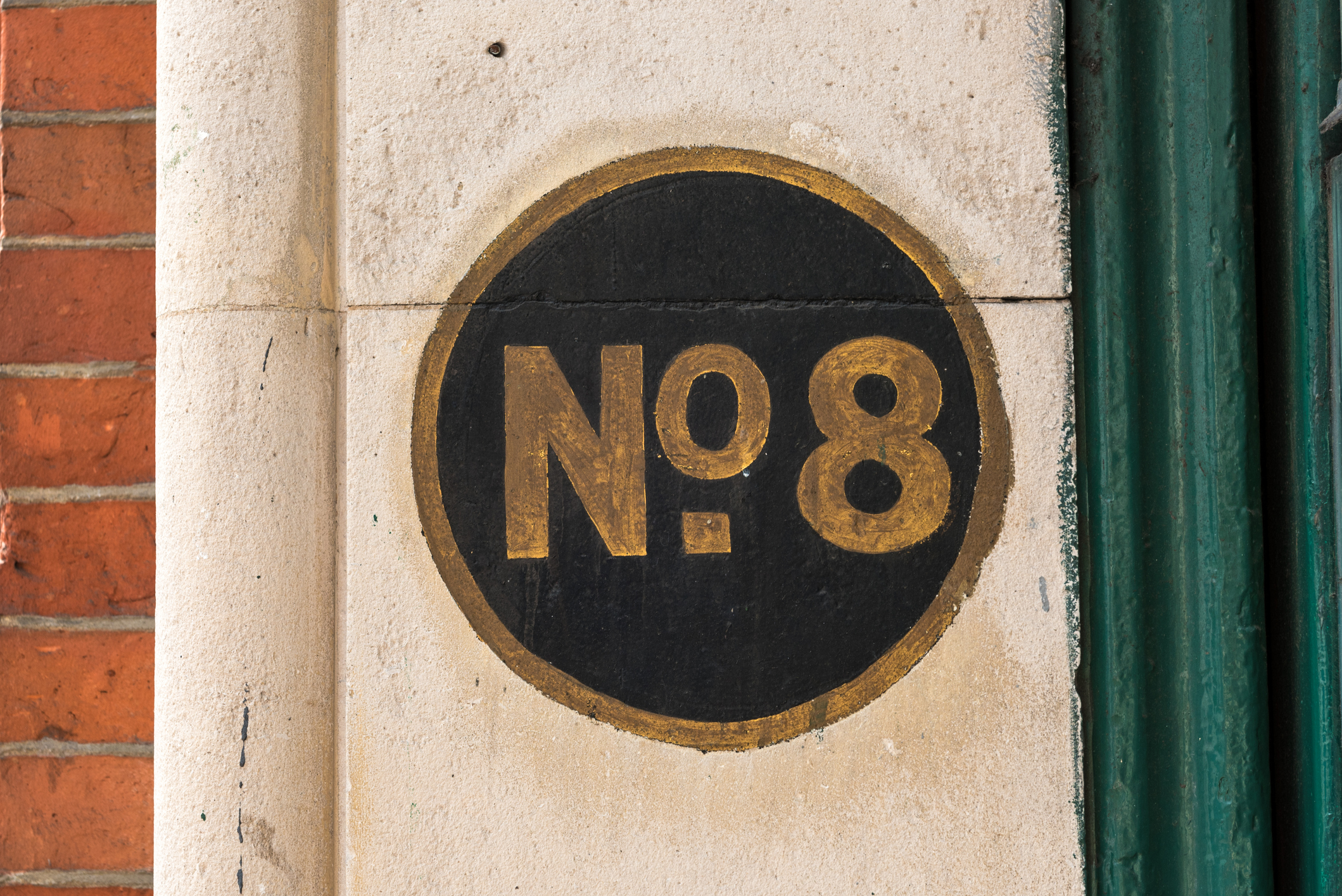 No. 8 or number eight painted on the surround of a door of a Victorian-era building in London, United Kingdom