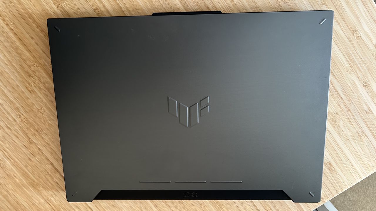 Asus TUF A15 gaming laptop lid on a wooden desk