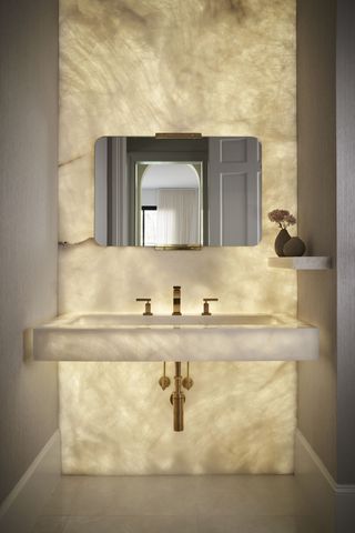 luxe powder room with backlit onyx wall, floating vanity and wallpaper