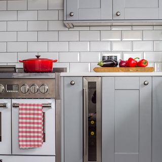 kitchen with white tile grey cabinet and electric stove