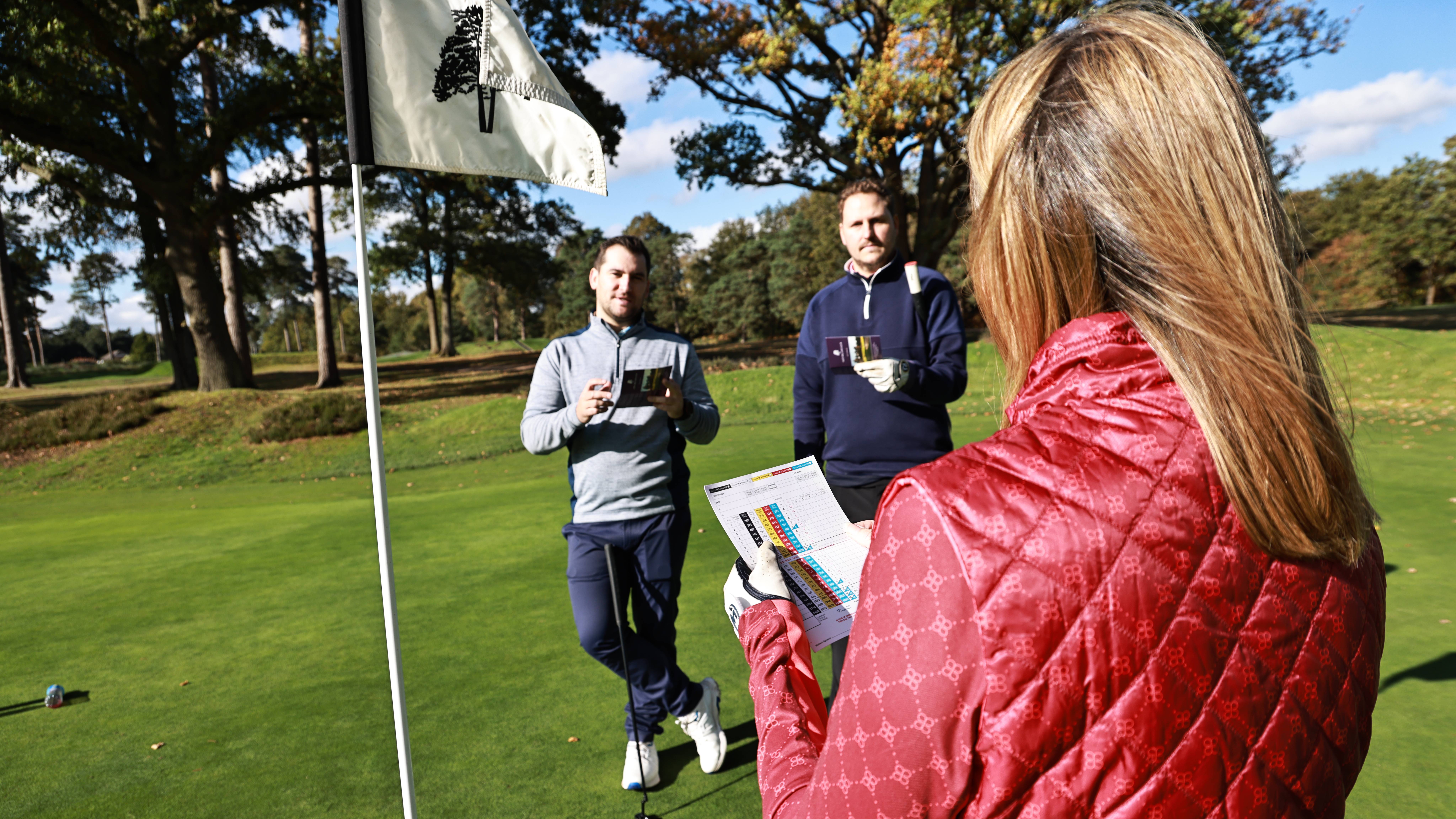 Golfers marking scorecards
