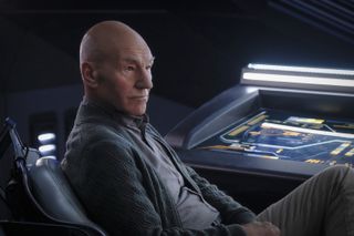 Huvudpersonen i Star Trek sitter i sin rymdstol och kollar på något utanför bild.