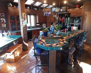 outdated kitchen with wooden cabinets and colorful tiles