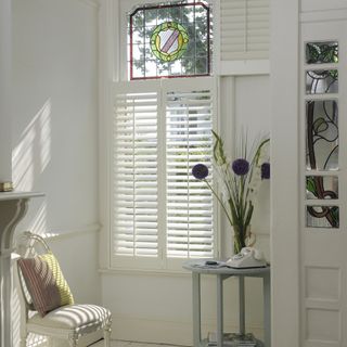 White hallway with window and shutters