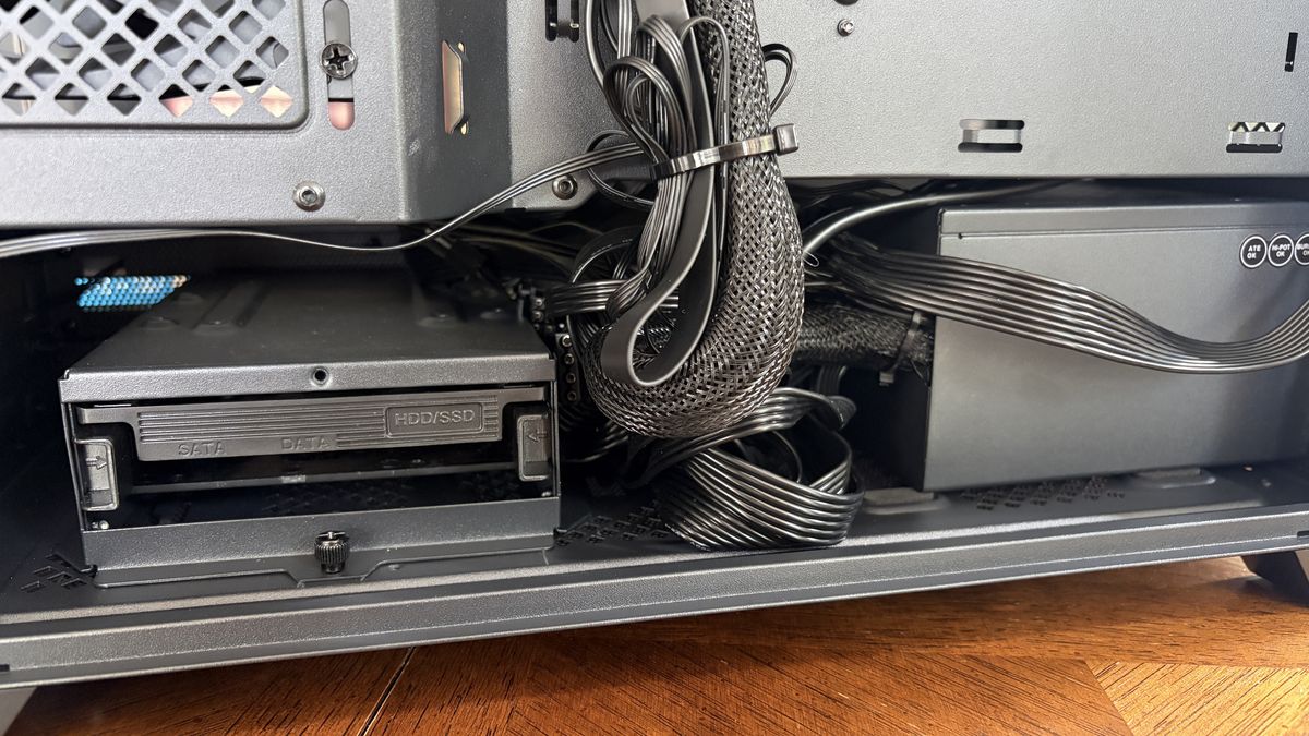 Interior of a Nitro 65 computer case showing a drive bay labeled "HDD/SSD" with cables and a power supply unit visible.