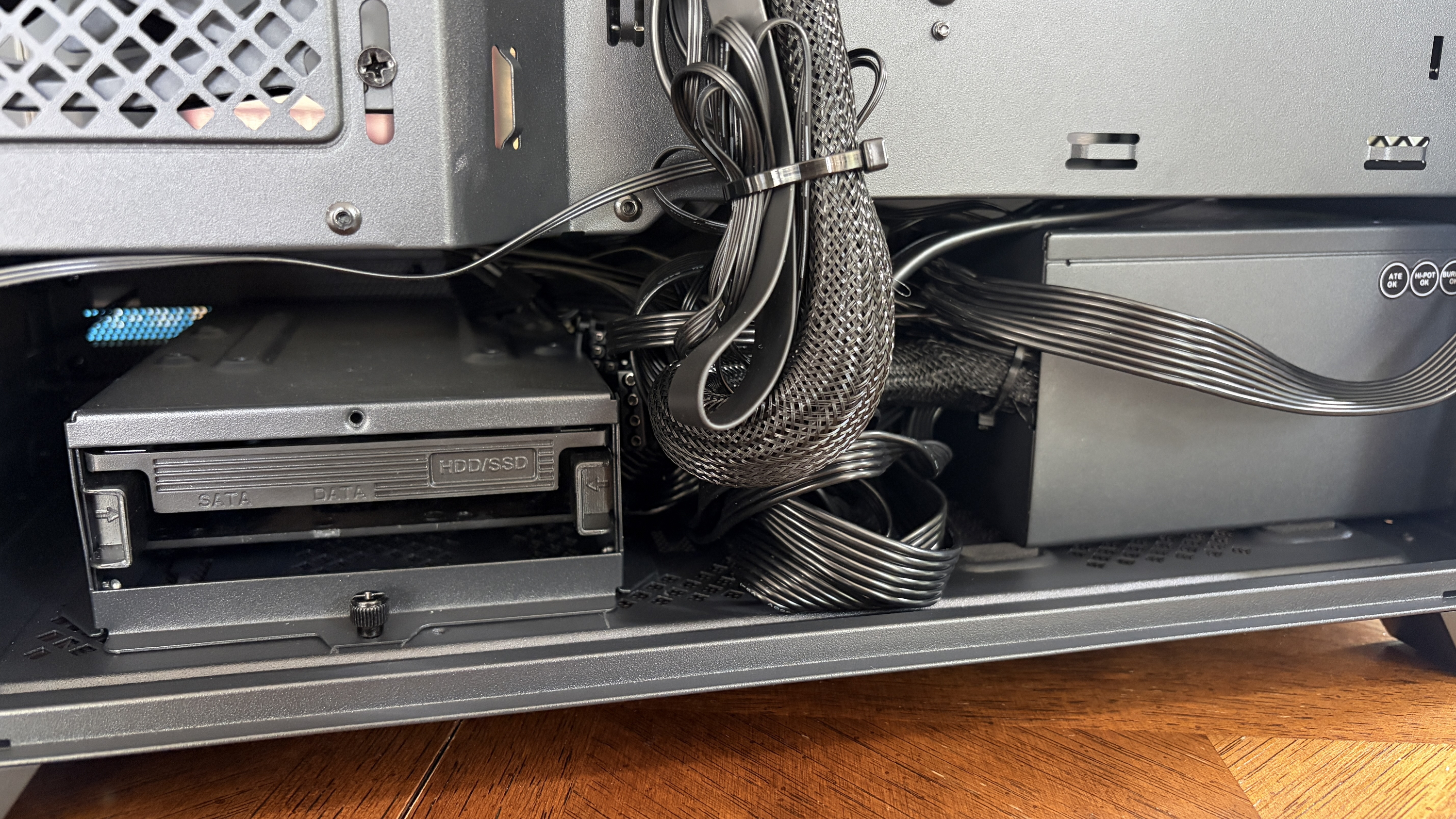 Interior of a Nitro 65 computer case showing a drive bay labeled "HDD/SSD" with cables and a power supply unit visible.