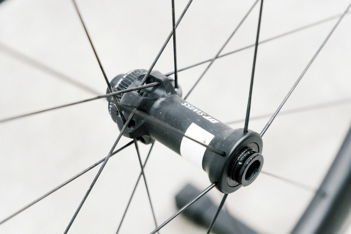 An aero road wheel stands against a white wall