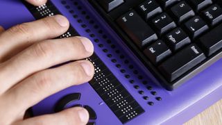 Somebody using braille on a computer keyboard