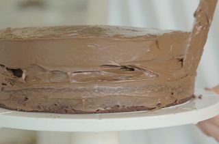 Spreading Nutella onto of the chocolate finger cake