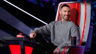 Adam Levine smiles in his chair during The Voice Season 27.