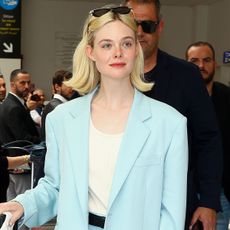 Elle Fanning wears a pale blue pantsuit at the airport