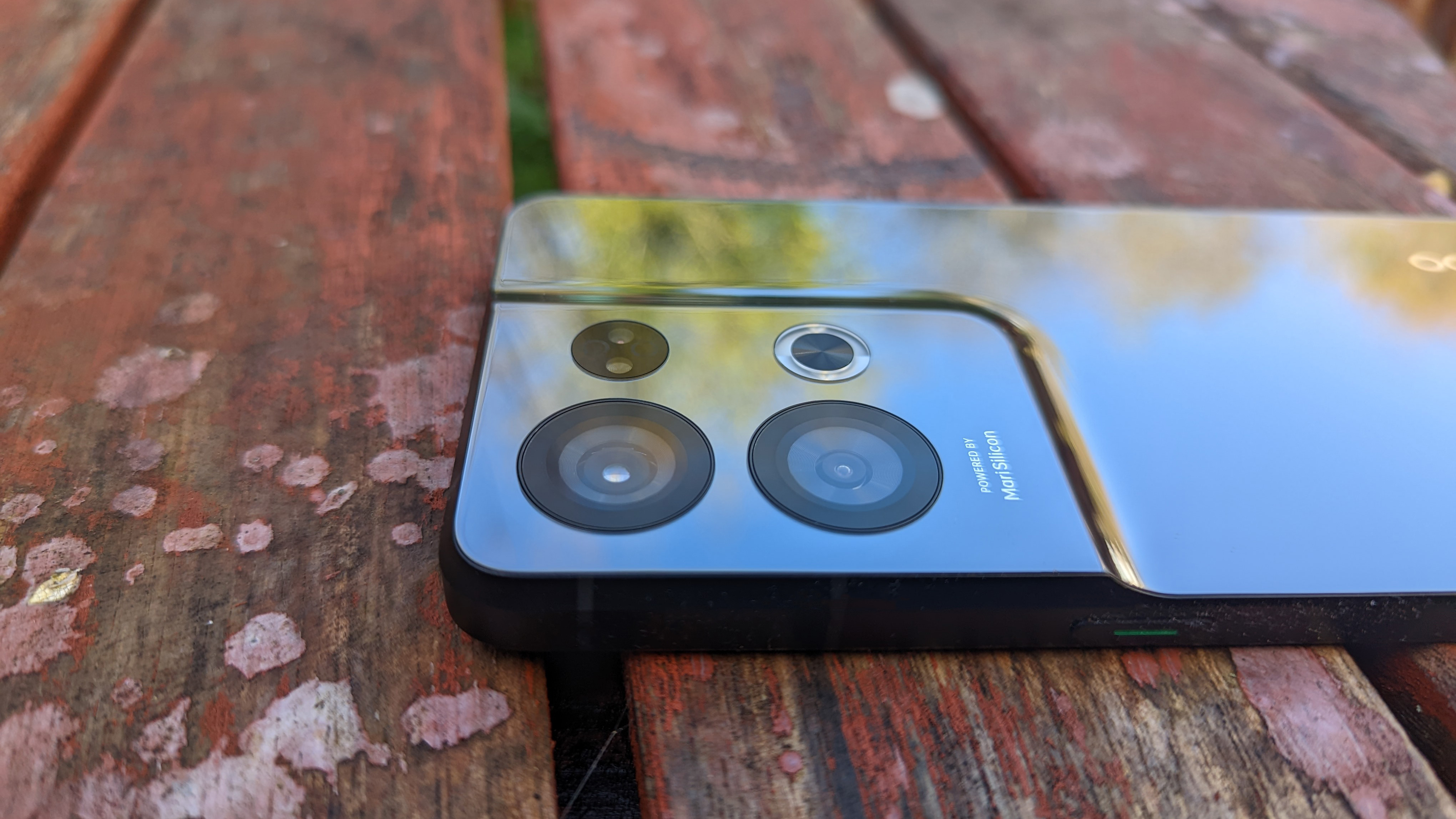 An Oppo Reno 8 Pro smartphone on a rustic table