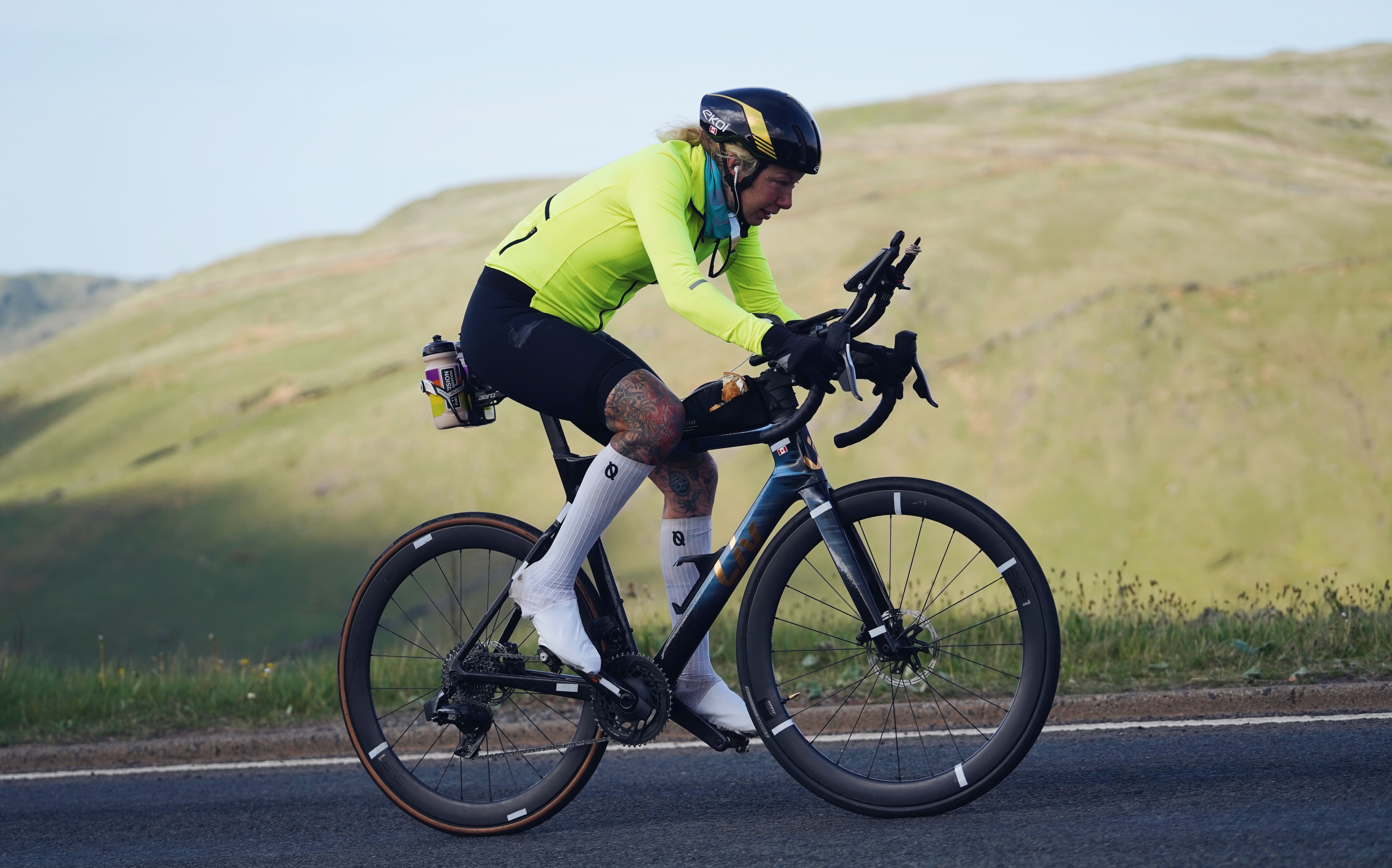 Sarah Ruggins cycling in a flourescent yellow jersey