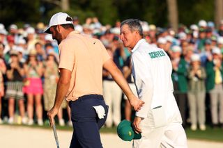 Scottie Scheffler and his caddie walk off the green at the 18th hole of Augusta National