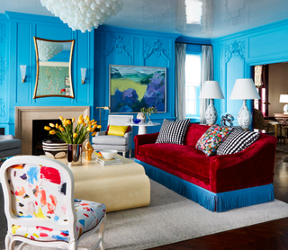 bright blue living room with red sofa by summer thornton