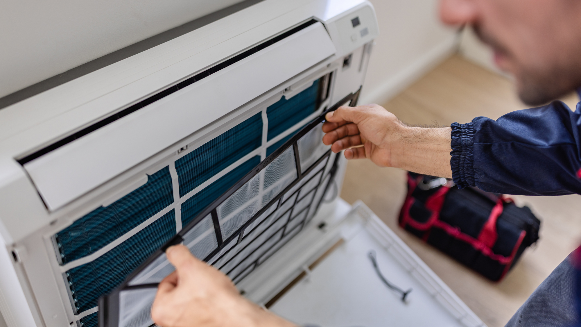 person holding the filter on an air con unit