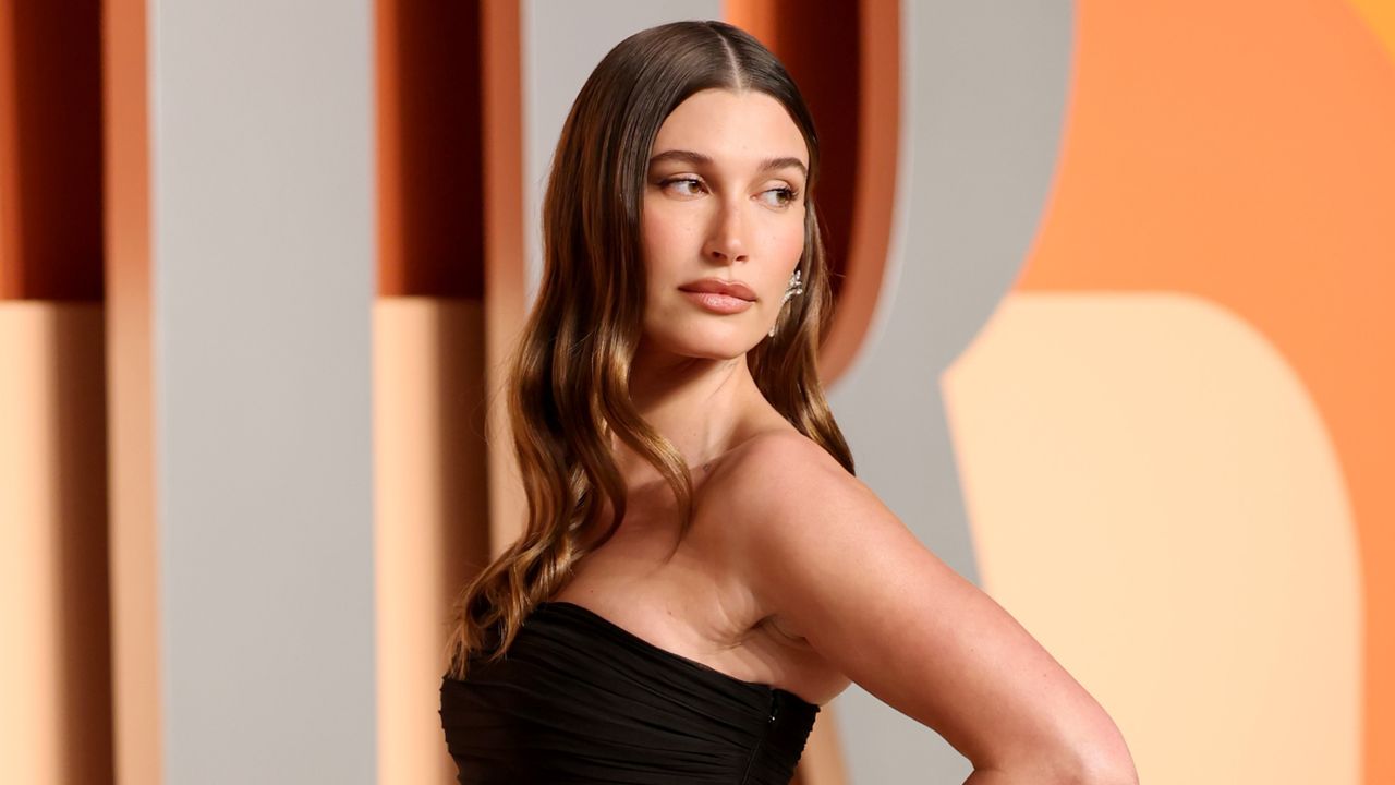 Hailey Bieber wears a strapless black gown with a sheer skirt to the Oscars Vanity Fair party