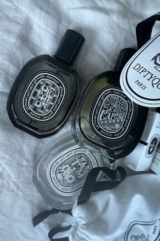 An image of various Diptyque perfumes scattered